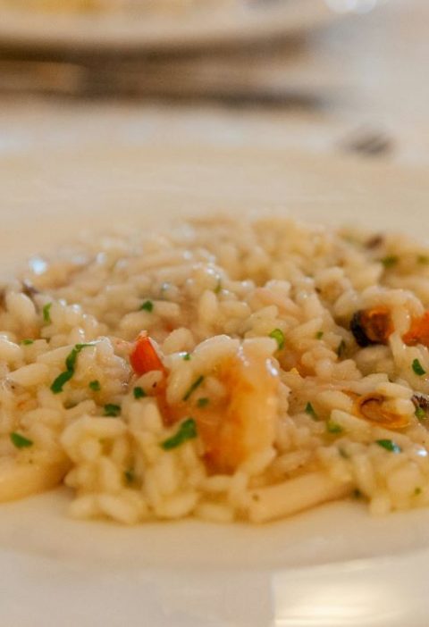 Foto de um prato branco com risoto de frutos do mar.