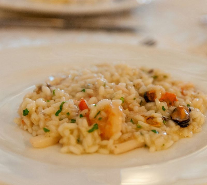 Foto de um prato branco com risoto de frutos do mar.